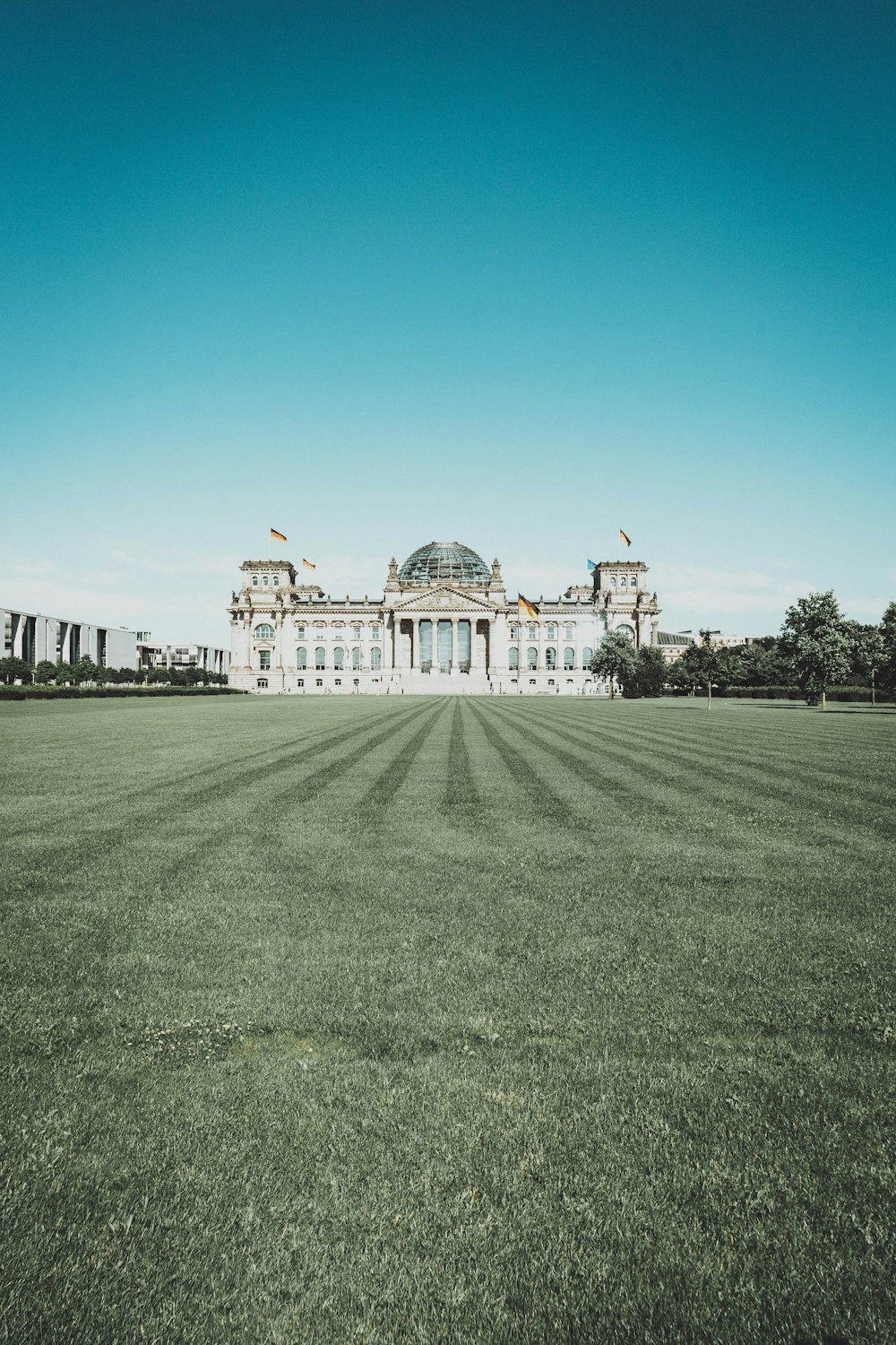 Weißes Betongebäude unter blauem Himmel tagsüber