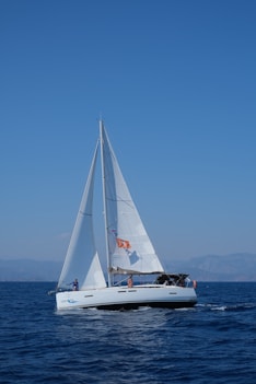 white sailboat on sea under blue sky during daytime