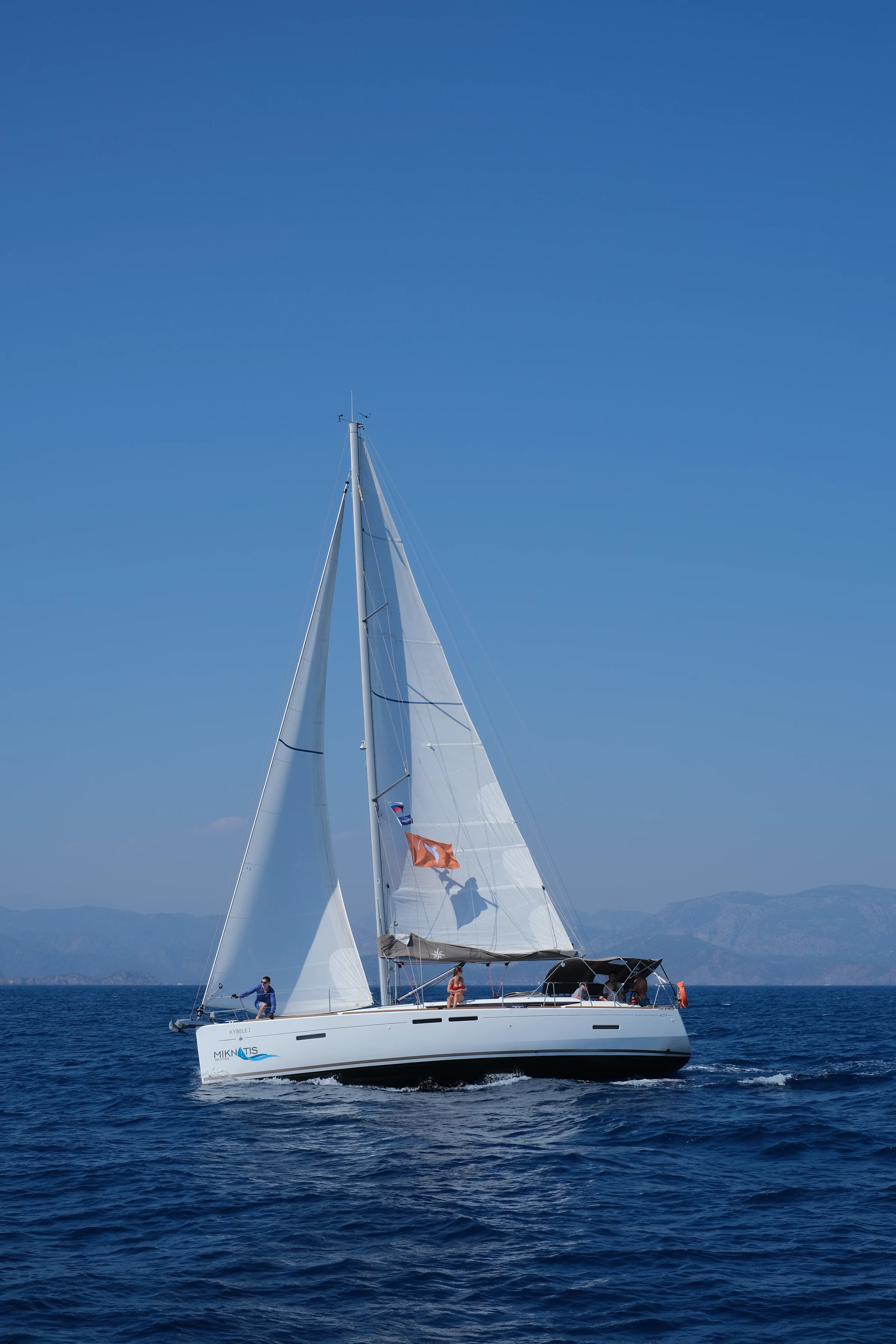 A white sailing yacht underway on open blue water