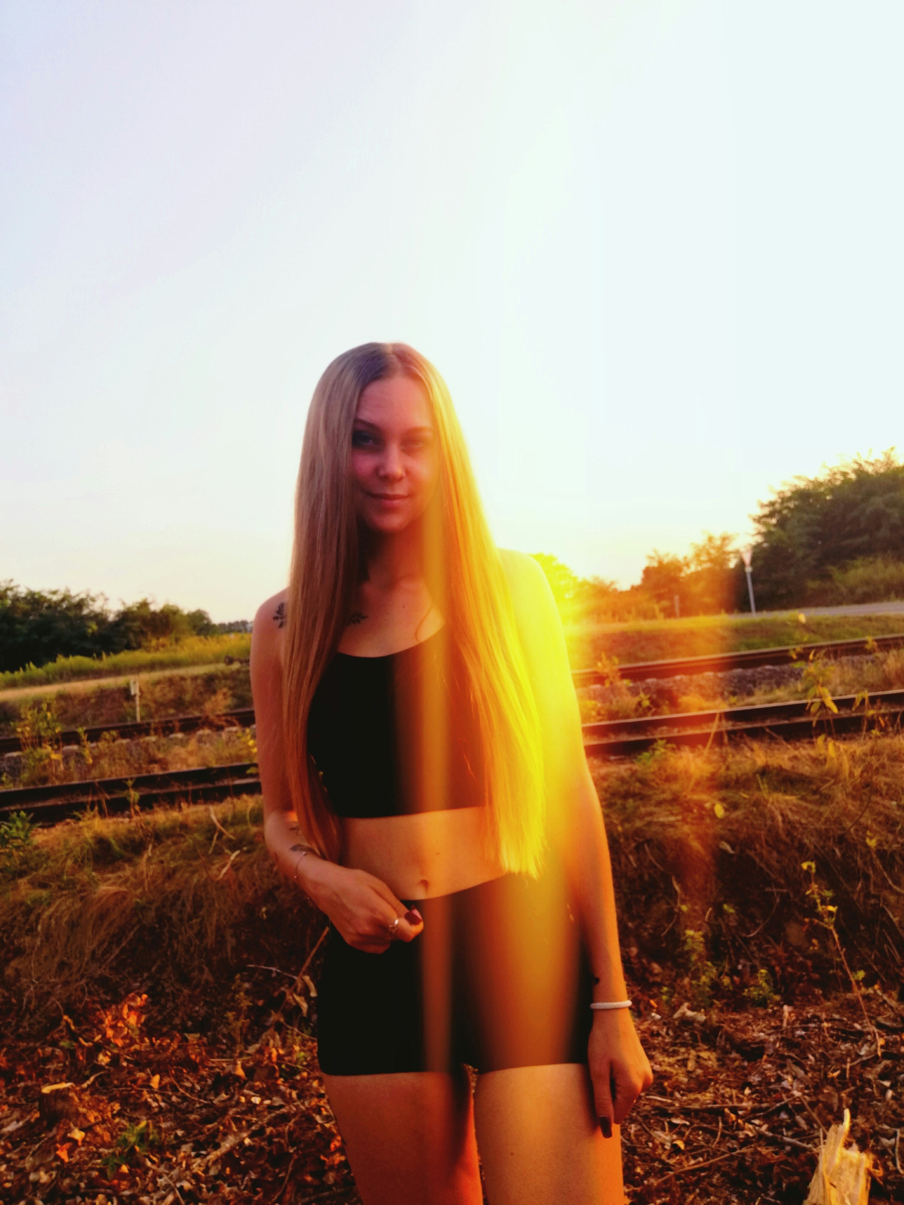 woman in black dress standing on brown grass field during daytime
