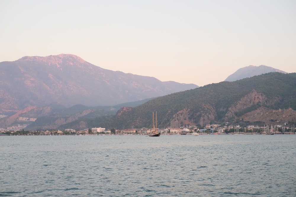 boat on sea near mountain during daytime