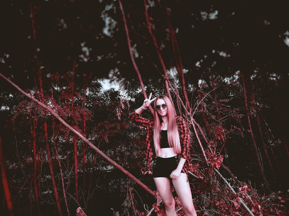 woman in black and white striped tank top and black shorts standing on forest