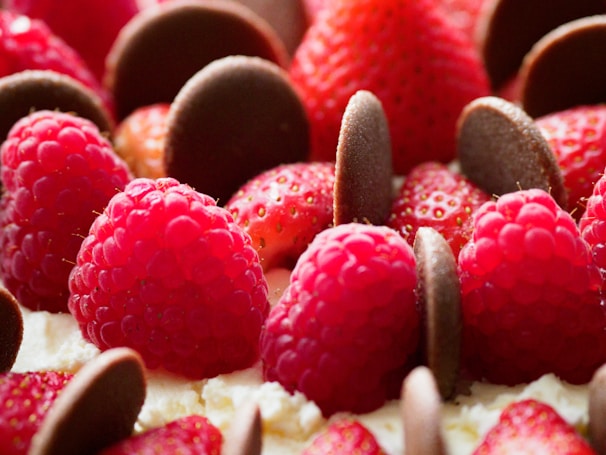 Elegant floral arrangement with strawberries dipped in chocolate on a minimalist white background