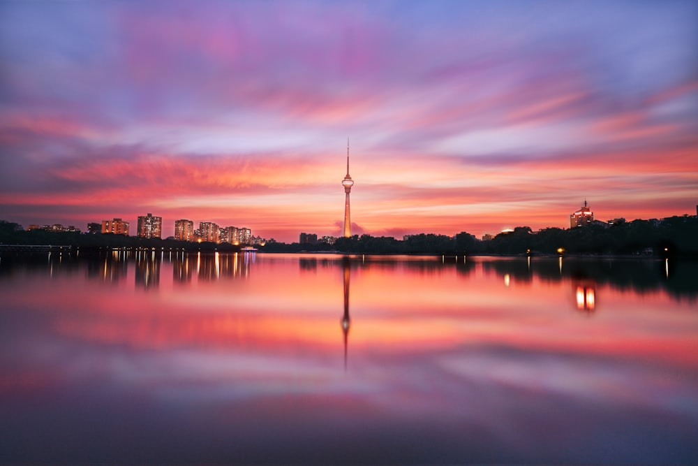 silhouette of building near body of water during sunset