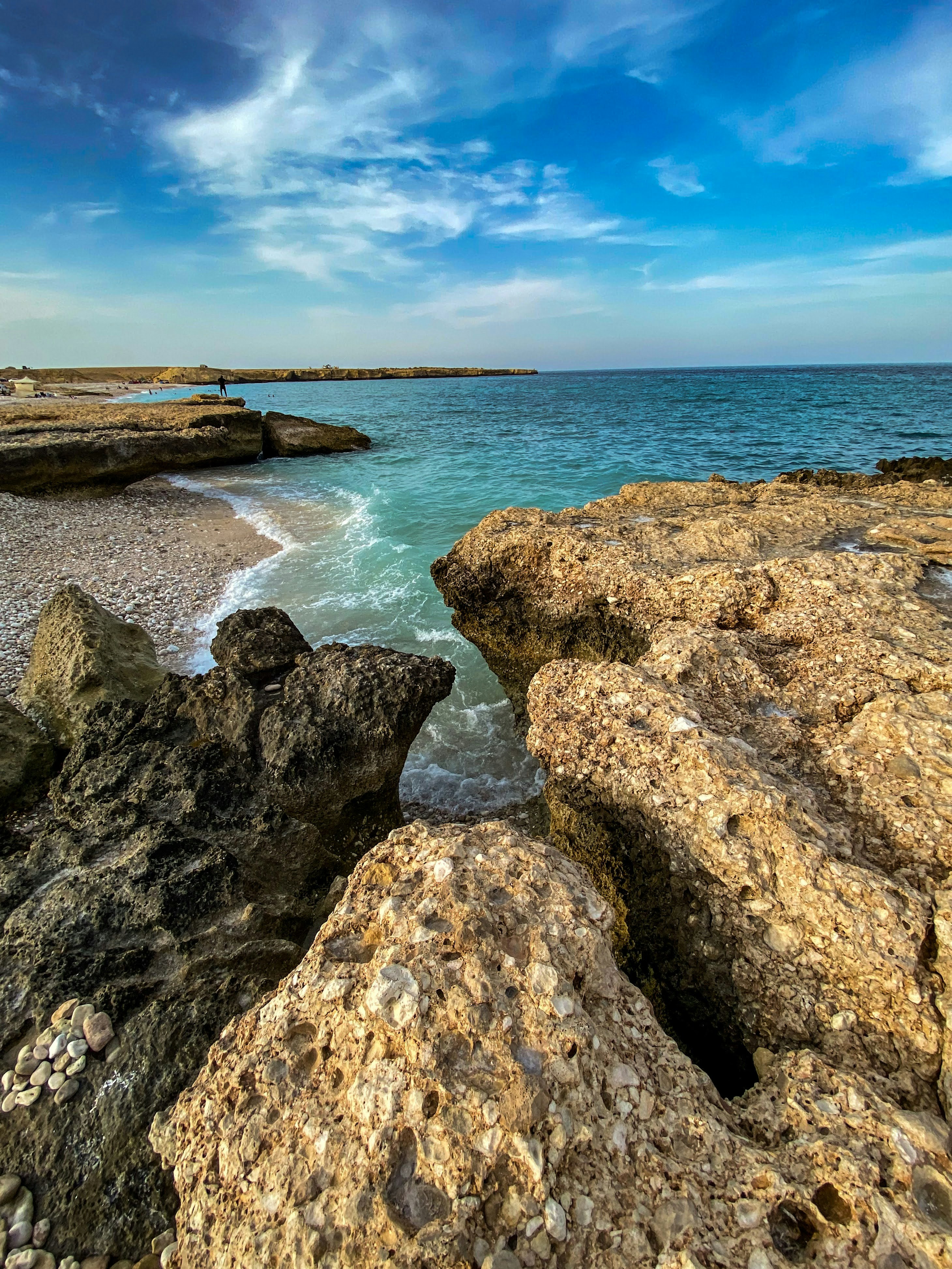 brown and gray rock formation near body of water during daytime