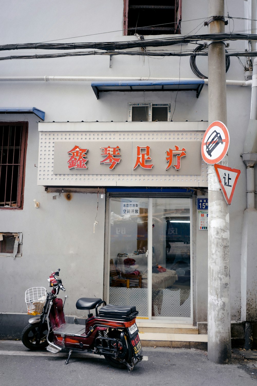 black motorcycle parked beside white concrete building during daytime