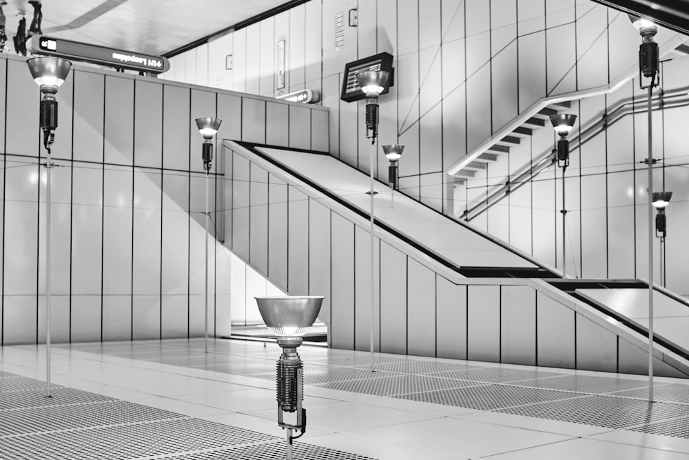 grayscale photo of woman walking down the stairs