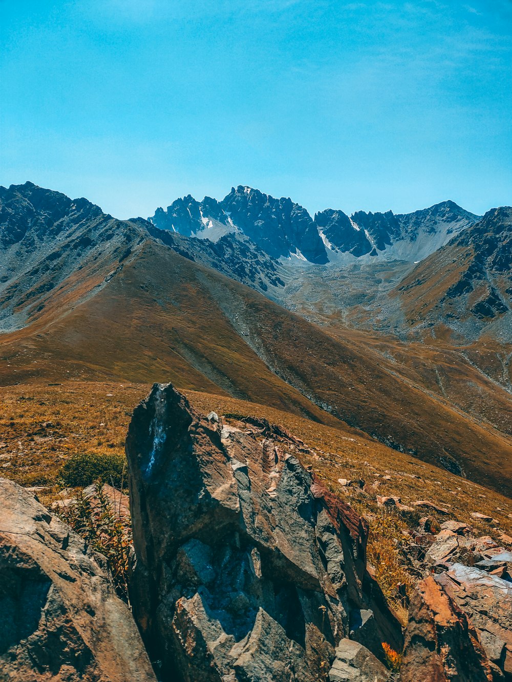 Montañas marrones y verdes bajo el cielo azul durante el día