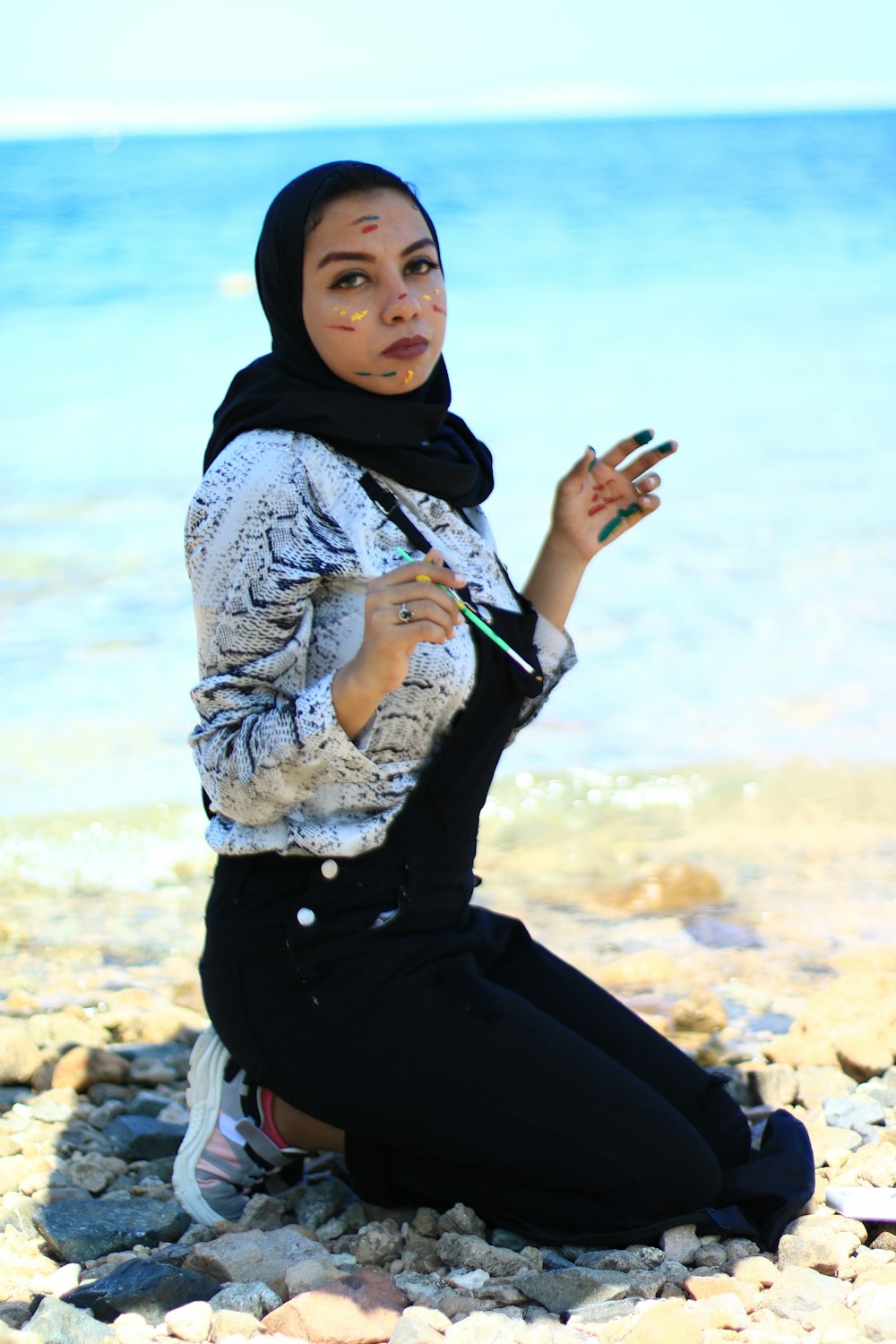 woman in black and white hijab and black and white long sleeve shirt sitting on brown