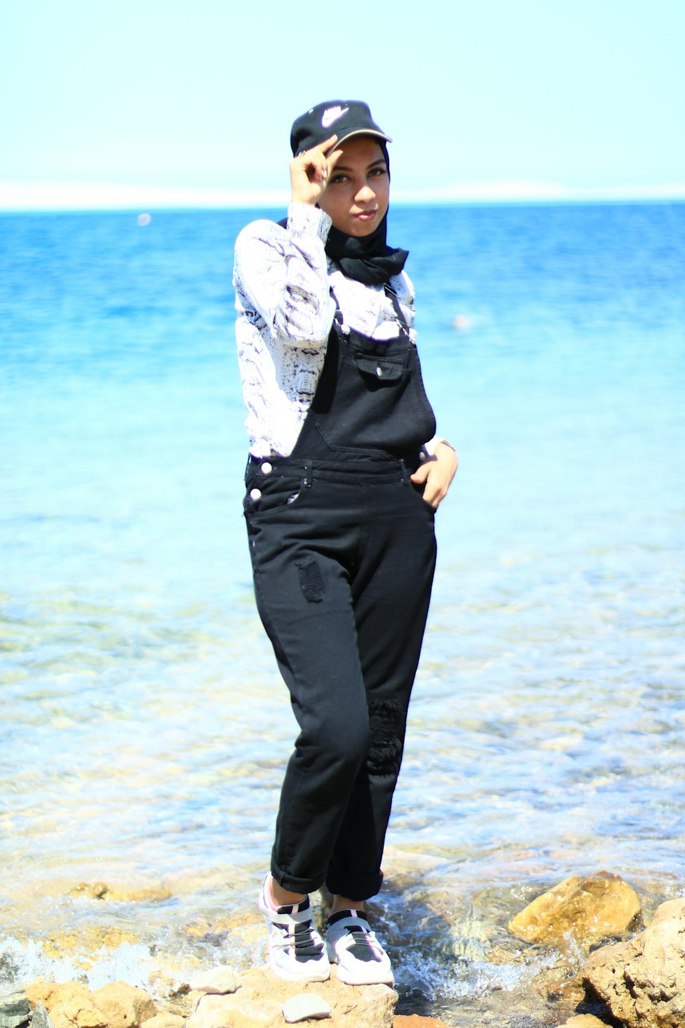 man in black pants standing on beach during daytime