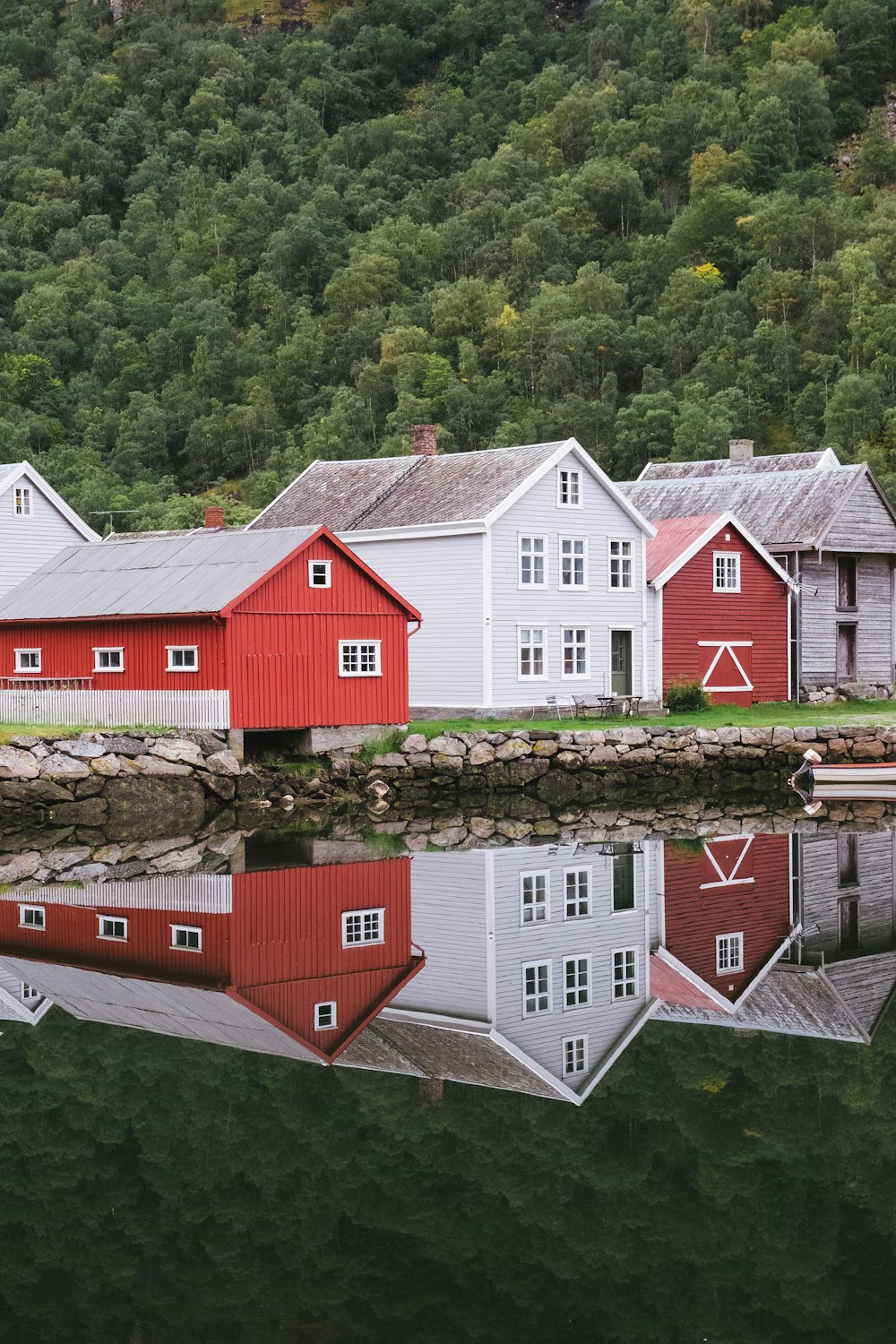 Casa de madeira vermelha e branca ao lado do rio durante o dia
