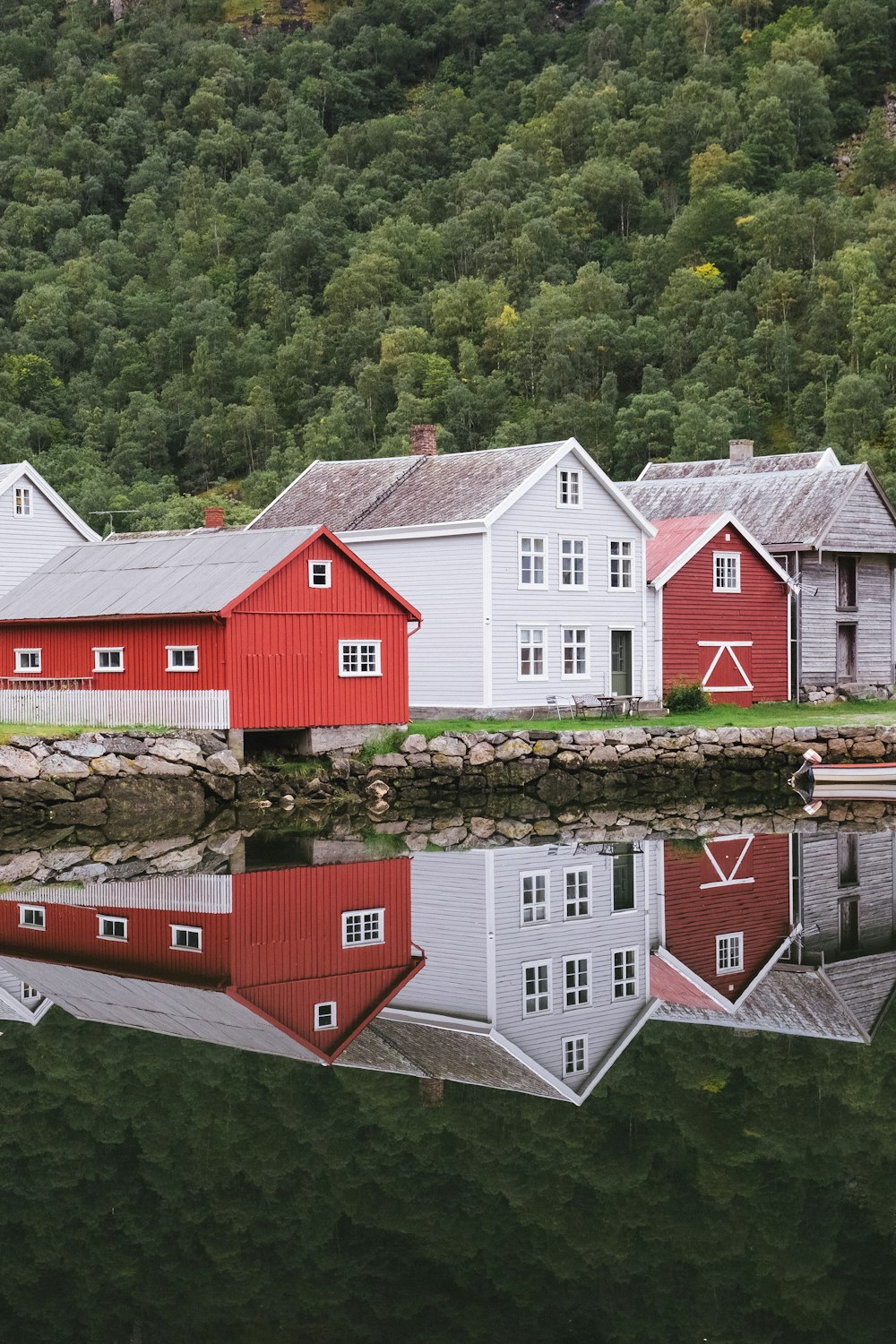 Casa de madera roja y blanca junto al río durante el día