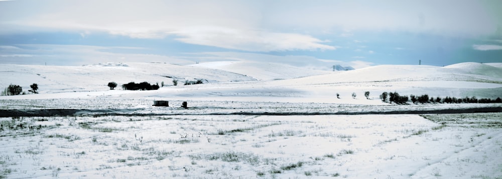 snow covered field under cloudy sky during daytime