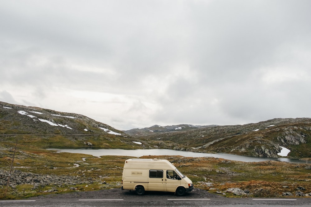 white van on green grass field under white cloudy sky during daytime