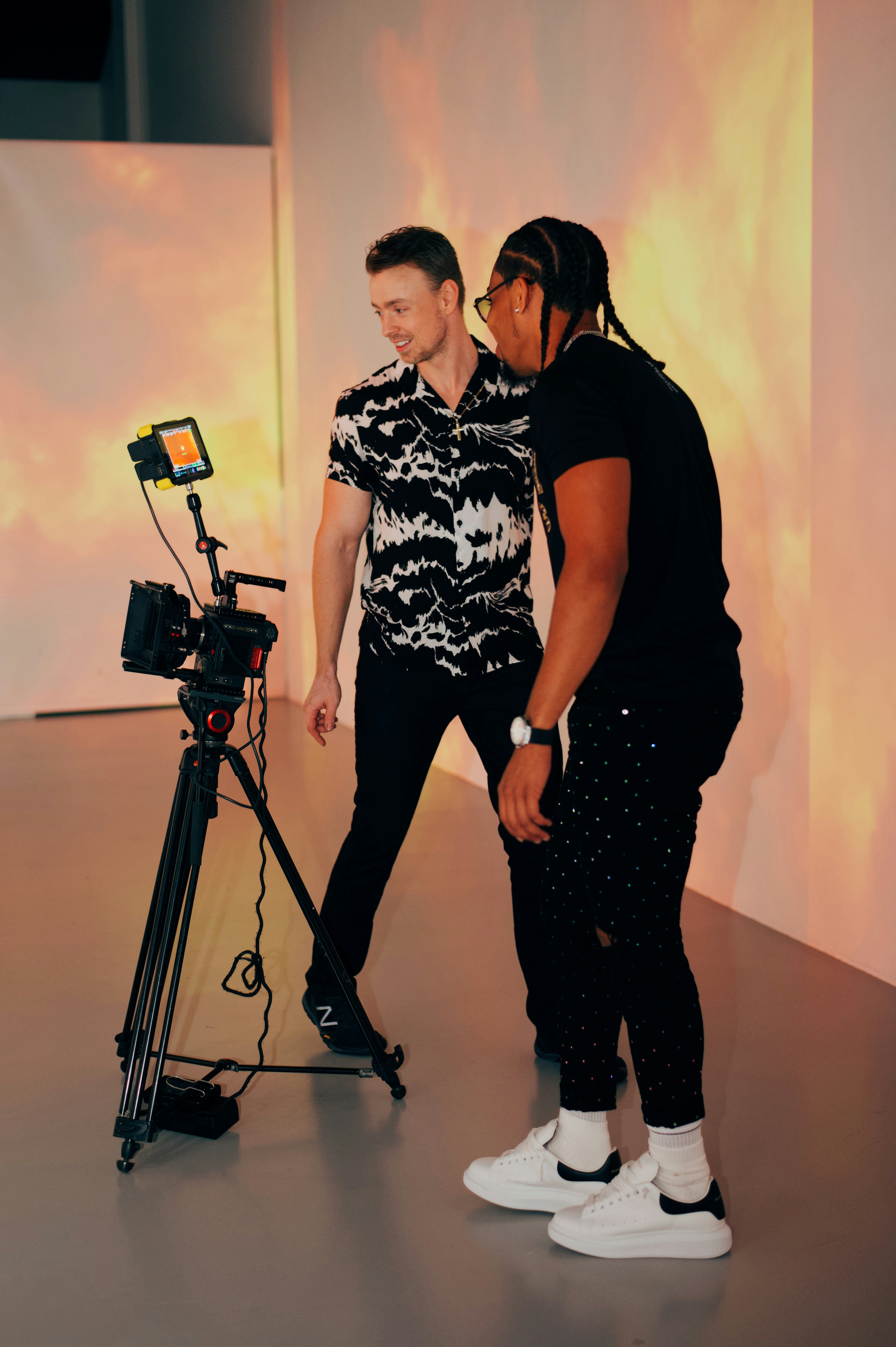 a man and a woman standing in front of a camera