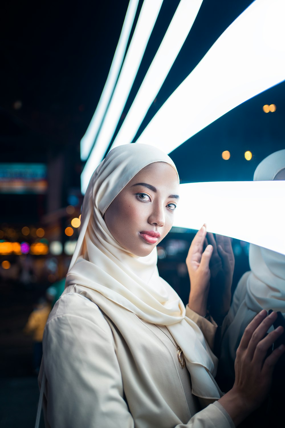 woman in white hijab holding white umbrella