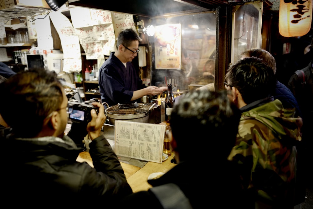 a group of people standing around a table