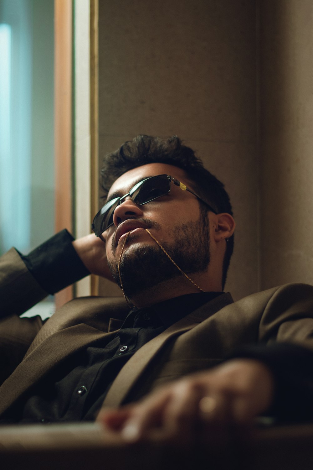 man in brown coat wearing black sunglasses