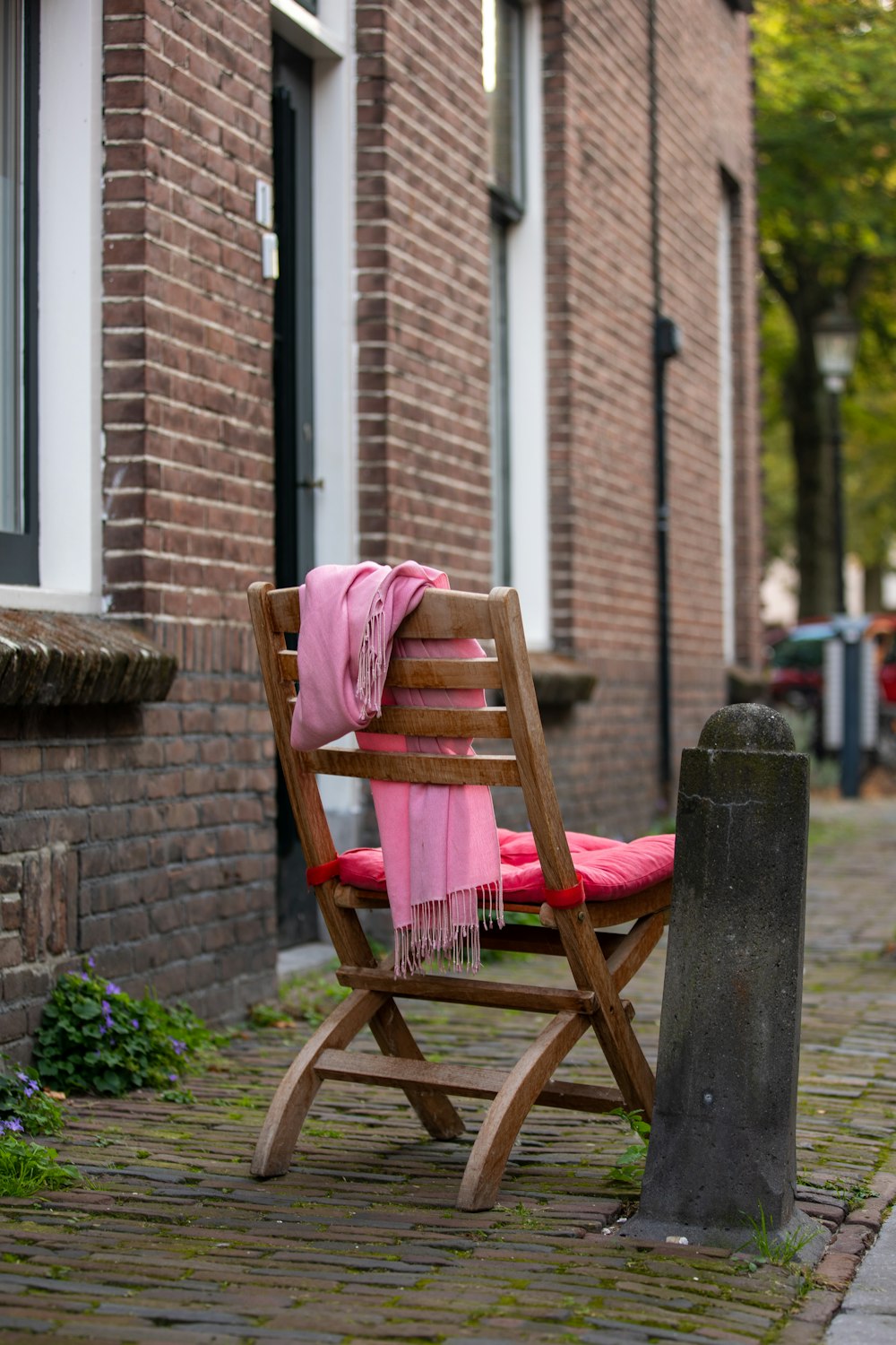 brown wooden chair with pink textile on top