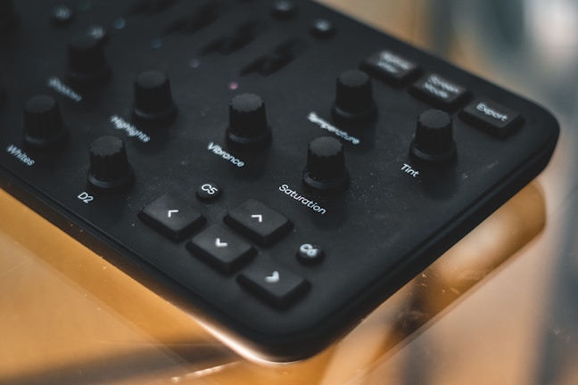 Hands adjusting color settings on a graphic design monitor in a studio.