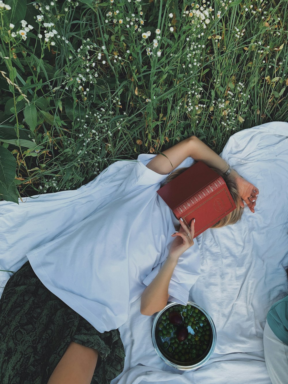 woman in white dress holding red book