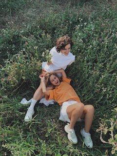 woman in white shirt sitting on green grass