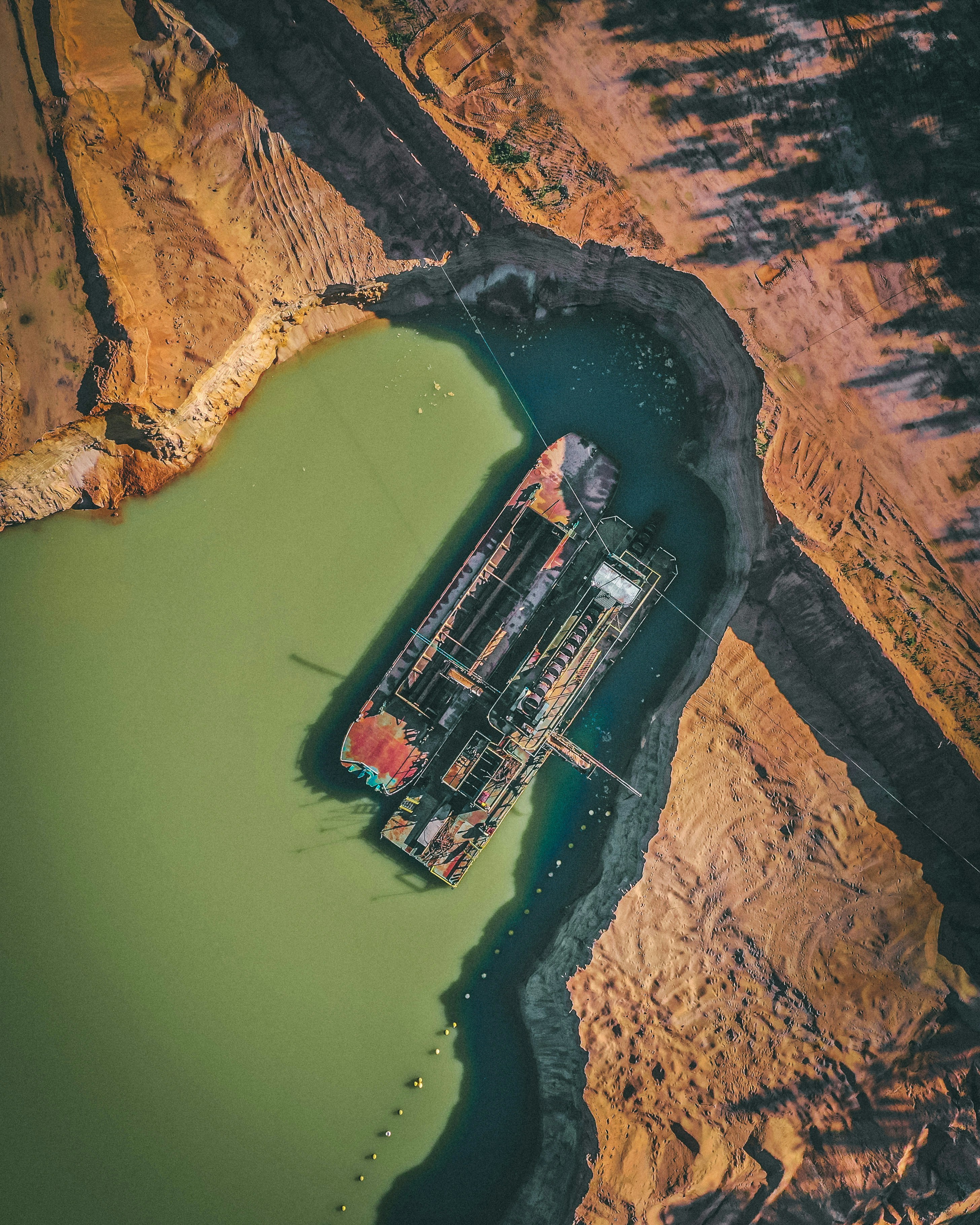 aerial view of red and white train on brown rocky mountain during daytime