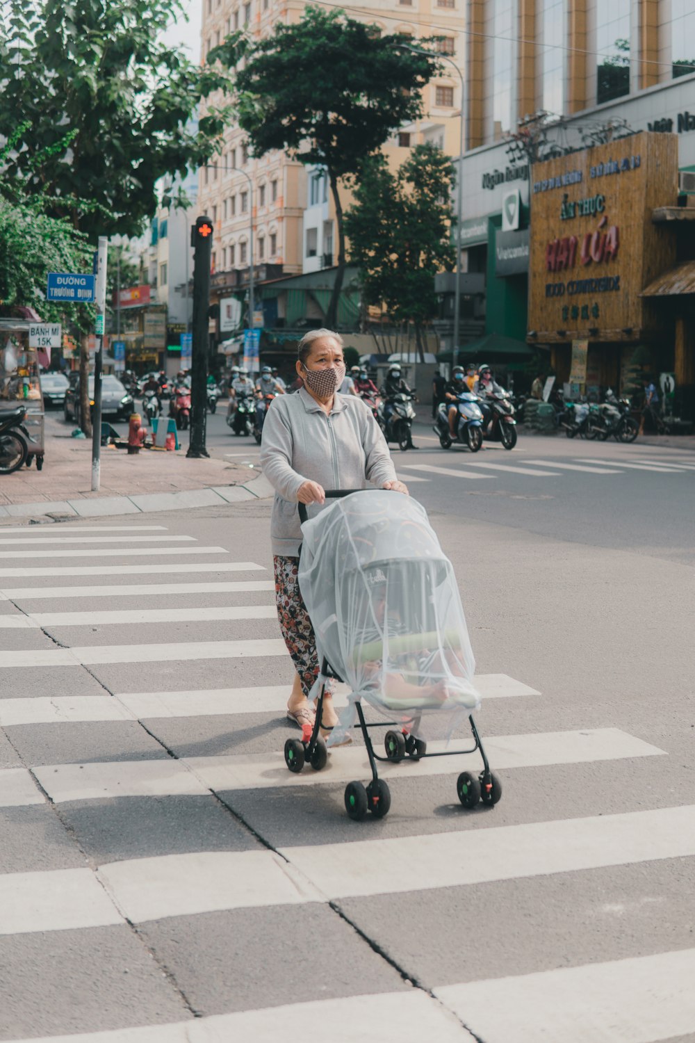 man in gray dress shirt riding on black and gray stroller on pedestrian lane during daytime