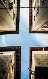 low angle photography of brown concrete building under blue sky during daytime