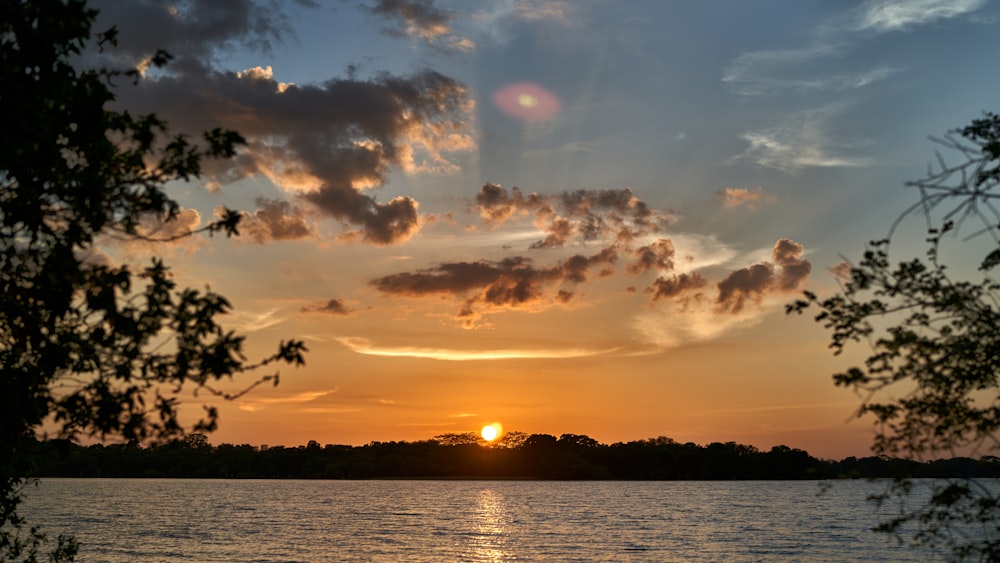 corpo d'acqua sotto cielo nuvoloso durante il tramonto