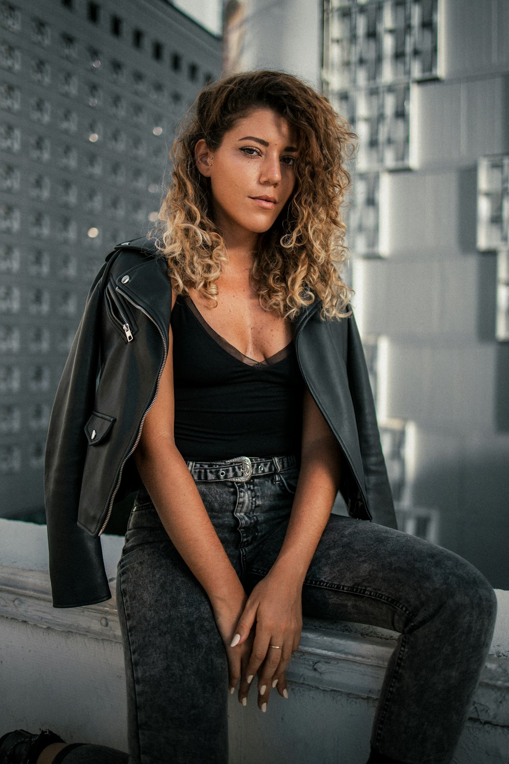 woman in black blazer and black dress sitting on the floor