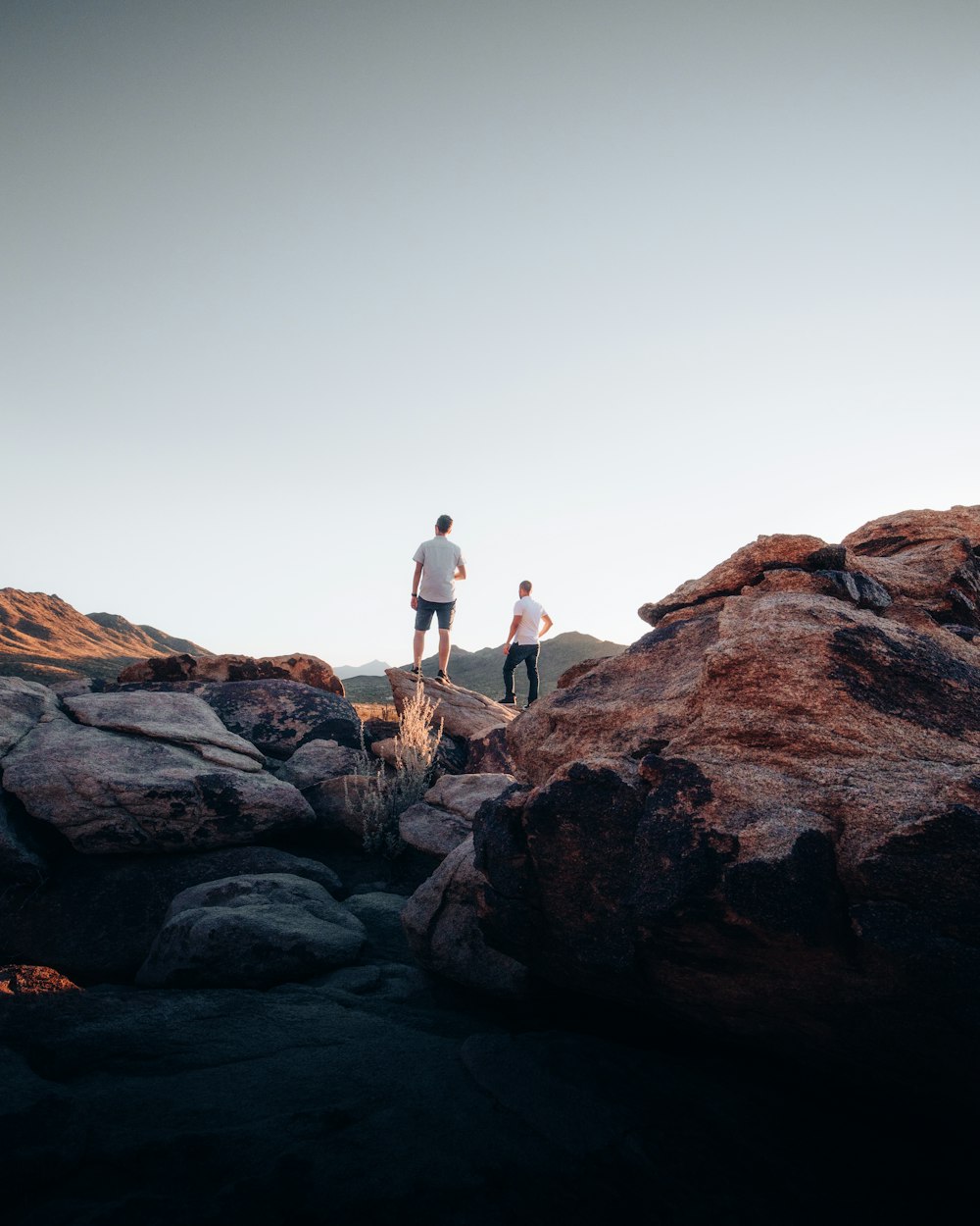 man and woman standing on brown rock formation during daytime
