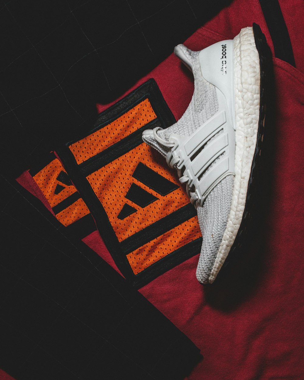 a pair of adidas running shoes on top of a t - shirt