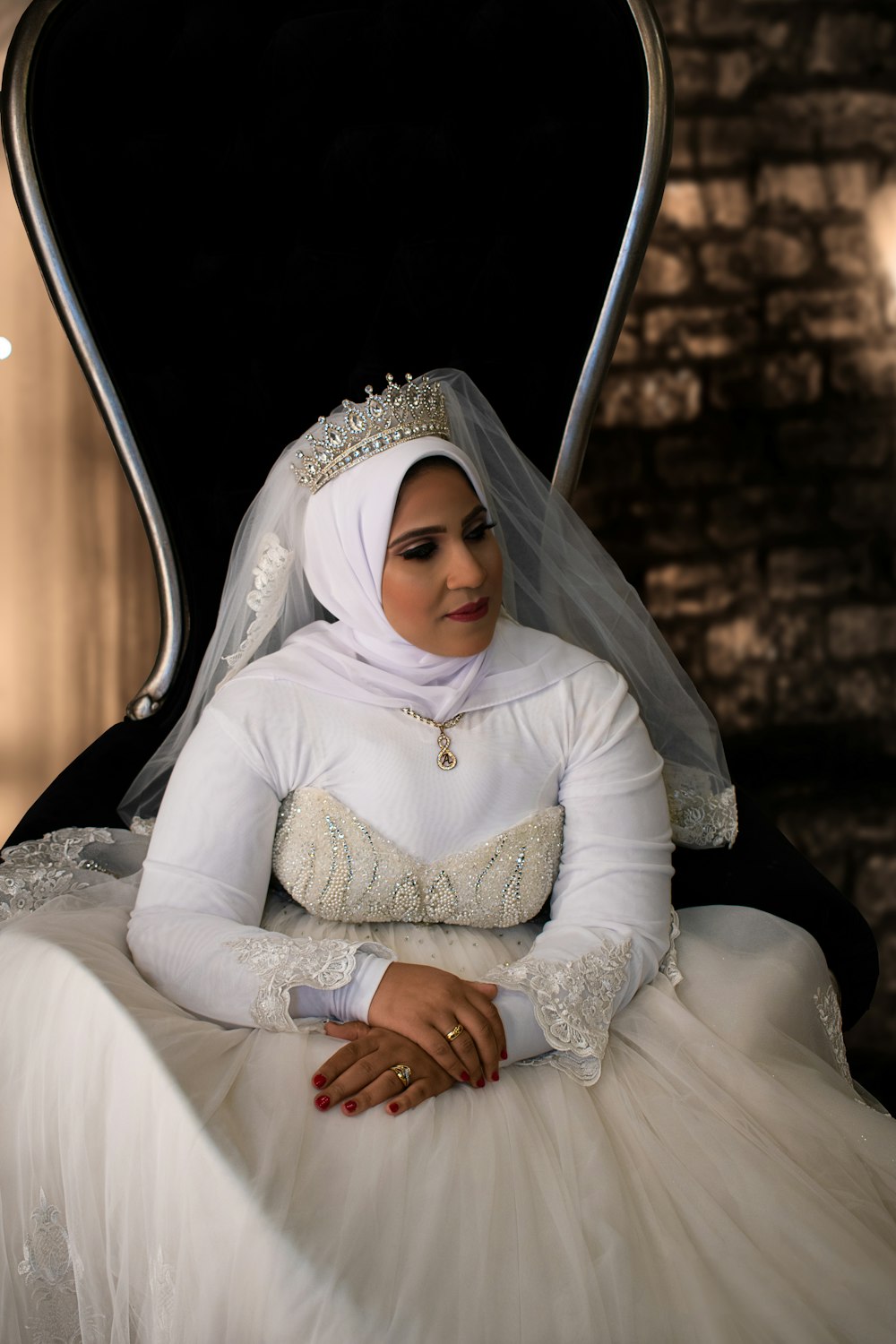 woman in white hijab sitting on white bed