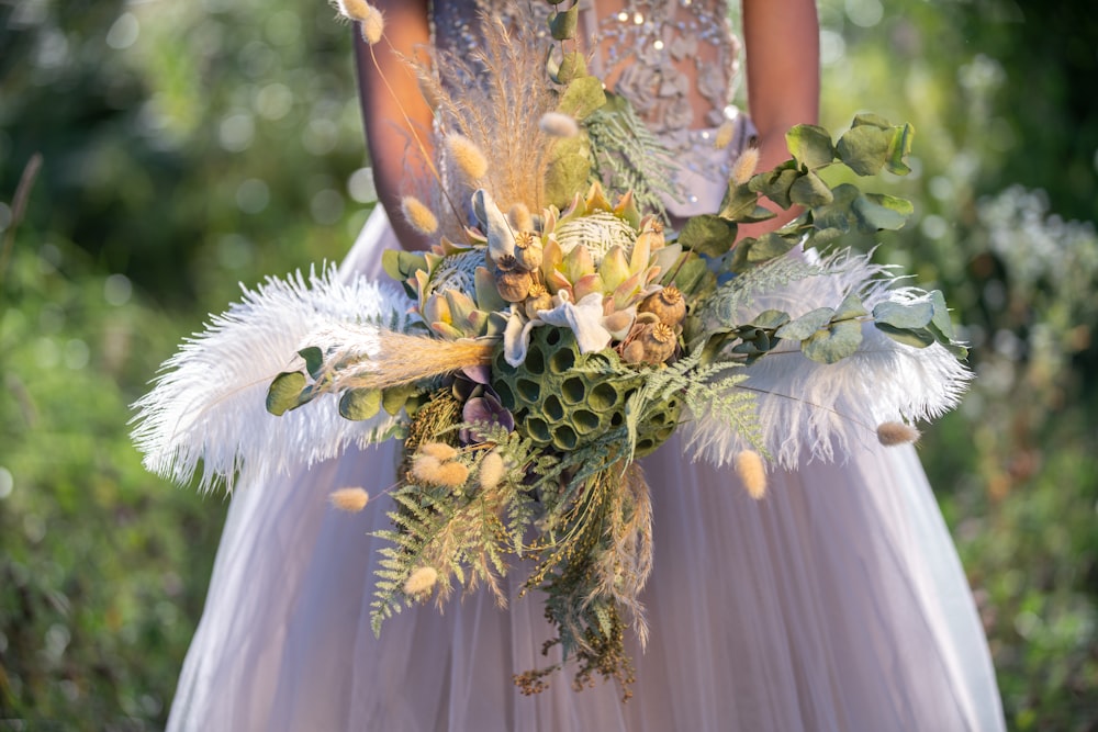 woman in white wedding dress holding white flower bouquet