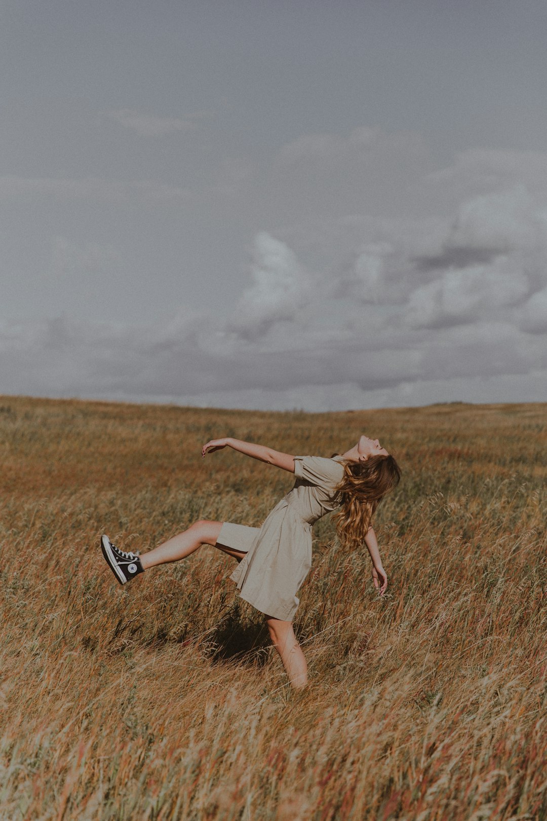 woman in white dress standing on brown grass field during daytime