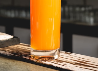orange juice in clear drinking glass