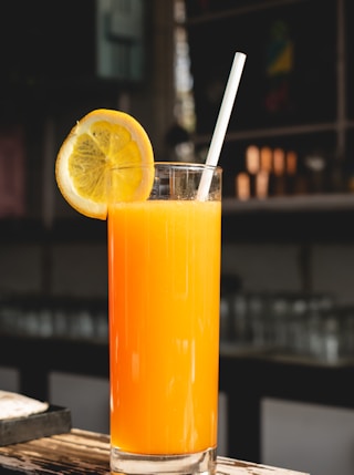 orange juice in clear drinking glass