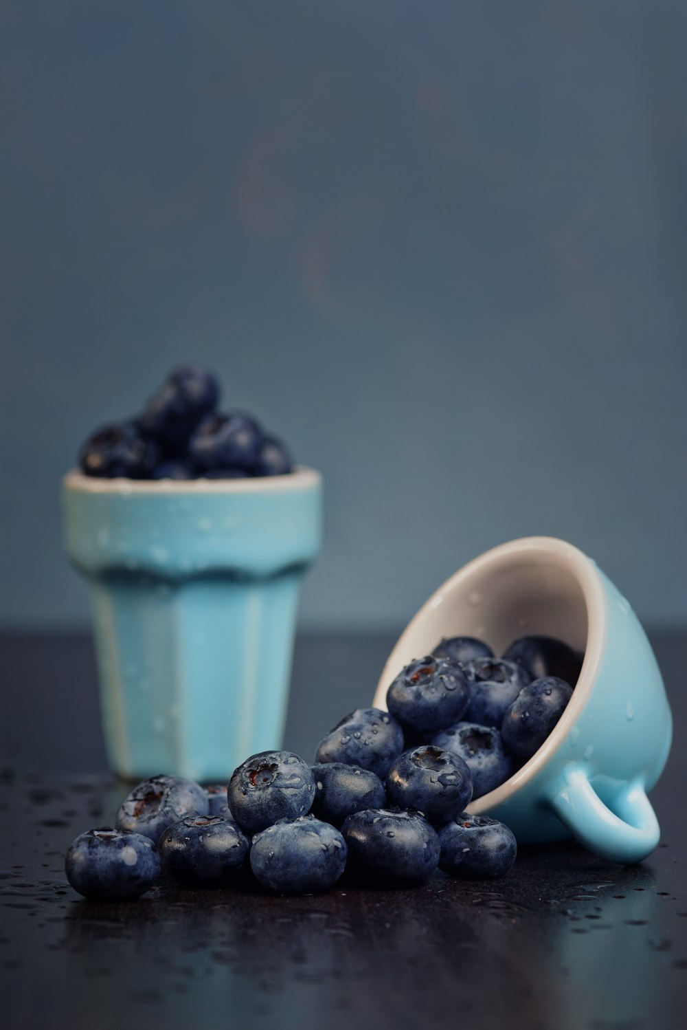 black berries in teal ceramic cup