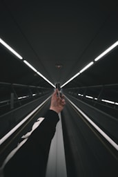 person in black pants walking on escalator