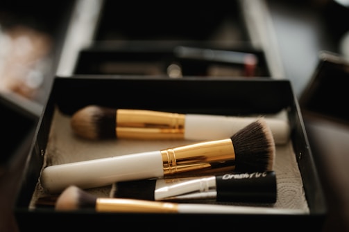 Close-up of colorful makeup brushes arranged on a white surface.