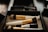 Close-up of hands applying makeup with brushes and natural cosmetics on a clean workspace.