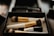 Close-up of hands applying makeup with brushes and natural cosmetics on a clean workspace.