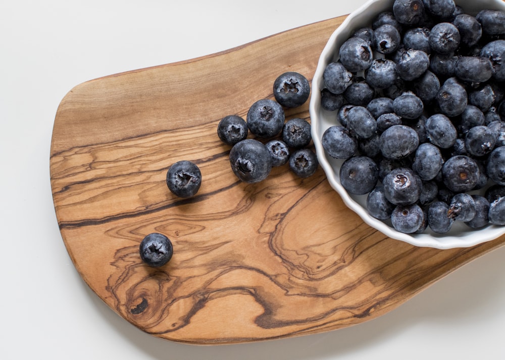 black berries on brown wooden chopping board