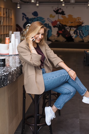 woman in blue denim jeans sitting on black metal seat