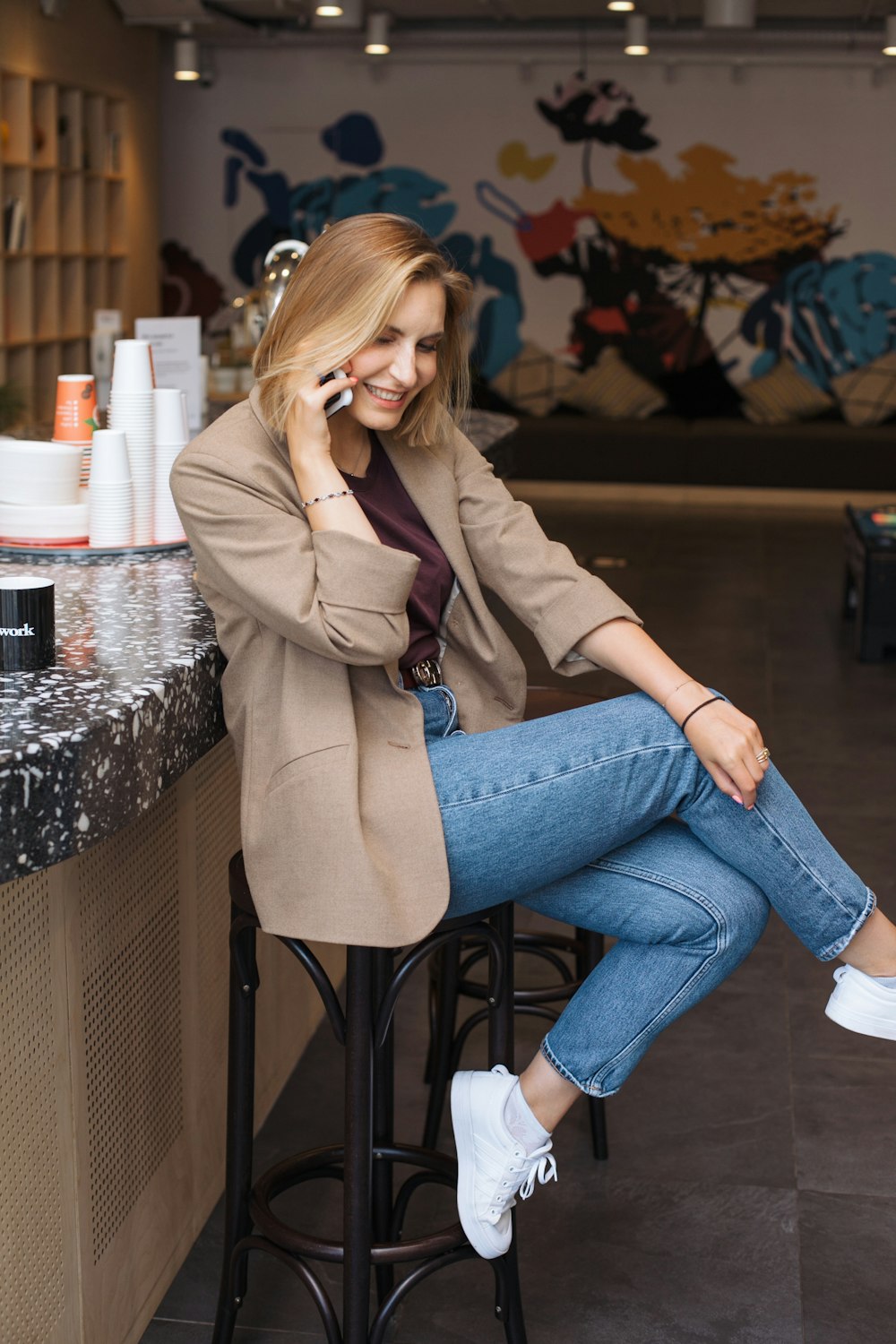 Mujer con jeans vaqueros azules sentada en un asiento de metal negro