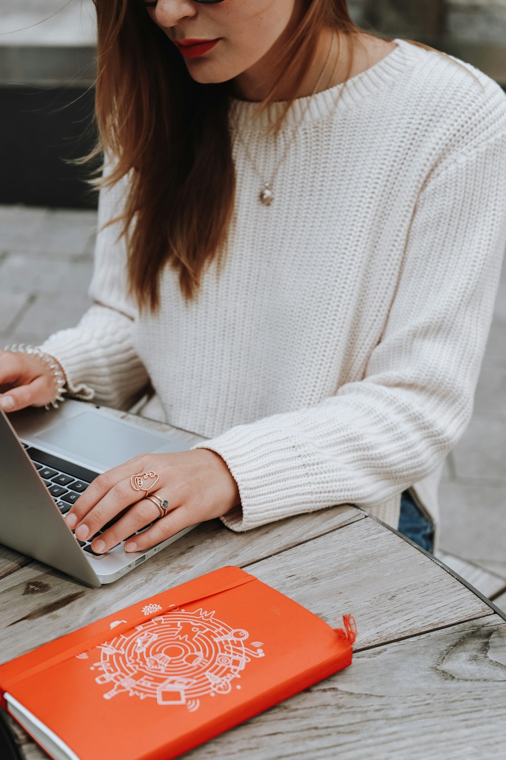 woman in white long sleeve shirt using silver macbook