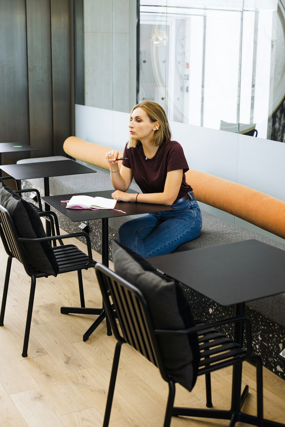 woman in blue denim jeans sitting on black chair