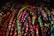 A vibrant array of intricately woven friendship bracelets displayed closely together. The bracelets feature a variety of patterns including zigzags, twists, and diamonds, showcasing a diverse palette of bright colors such as pinks, blues, greens, and yellows.