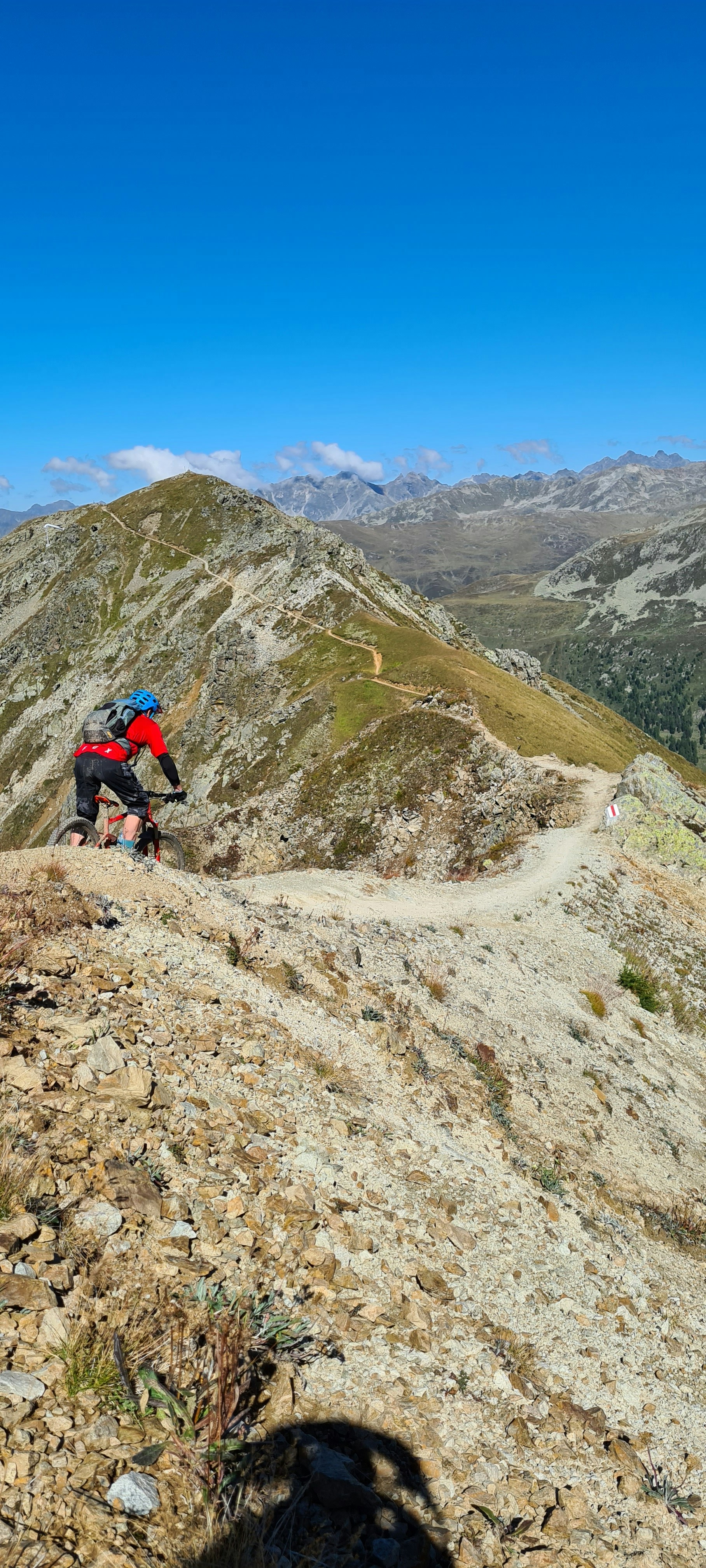 man in black jacket and black pants riding bicycle on mountain during daytime